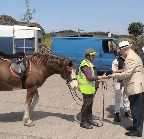 Warren Smith, The Lord Lieutenant of Greater Manchester, presenting a participant with her rosette