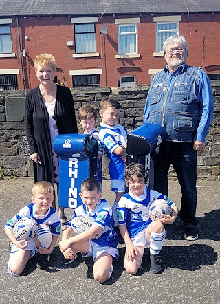 Sheila Whitworth and Mark Owen of the Friends of the Carnegie present some of the Mayfield Mustangs U7s with brand new tackle pads and other training equipment