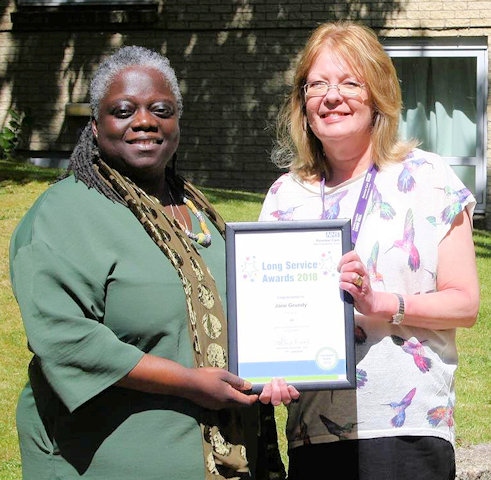 Evelyn Asante-Mensah OBE (left), presenting Jane Grundy (right), Senior Dental Nurse, with her Long Service Award