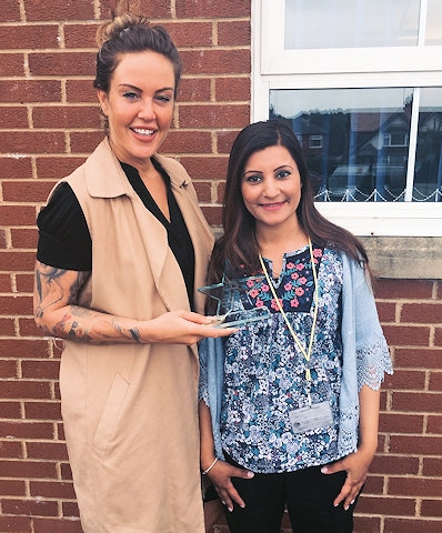 Saima Mahmood (right) receiving her award from Rebecca Clarke, Manager of PK Education's Manchester office