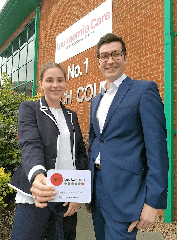 Bethany Torr and Zack Pemberton-Whiteley of Leukaemia Care with the leukaemia symptoms card