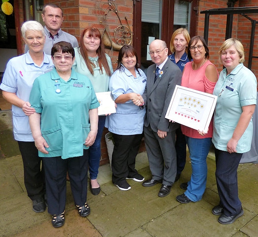 Deputy Mayor, Councillor Billy Sheerin, assistant cabinet member for adult care, congratulates staff at Hulton Care Home in Middleton on their achievement 