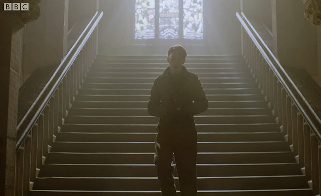 Tom walks down the staircase into the army recruitment centre