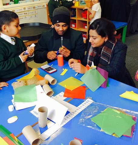 Lots of mums and dads enjoying spending time with their children making superhero crafts