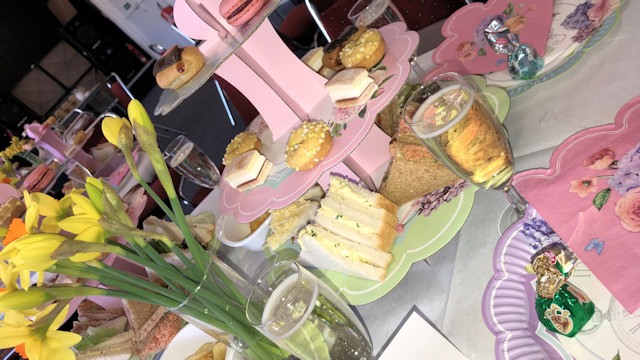 Cakes on a cake stand with a glasses of bubble and daffodils