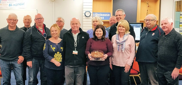 Lighthouse Project staff team, in the centre,  Dave Melia, Cath Stott (with the cake), Pam Semp, and Carl Roach behind, along with members of the weekly photography group which meets every Wednesday