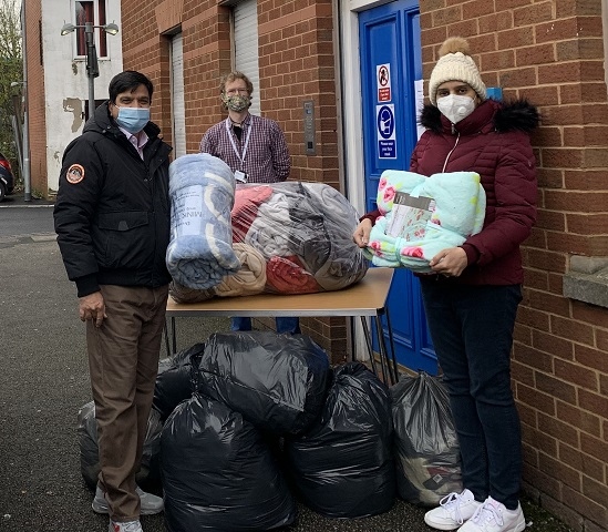 Councillor Faisal Rana and Iram Faisal hand over the blankets to Petrus manager Edmund