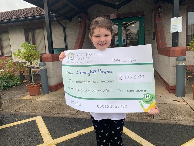 Lottie Harnett with the cheque for Springhill Hospice