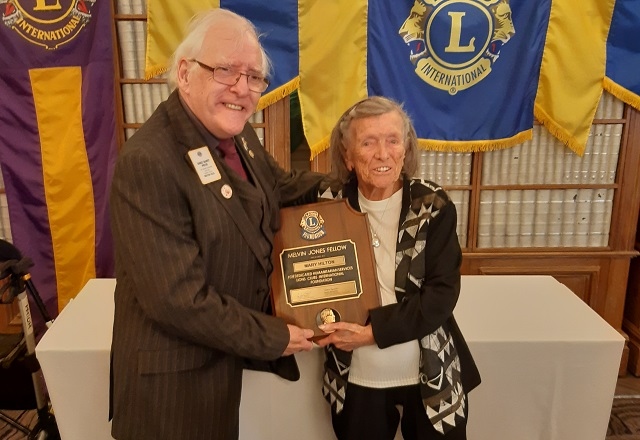 Immediate past district governor Lion Barry Prior presents the Fellowship to Mary Hilton