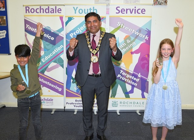 Children’s champion Grace (right) and deputy children’s champion Hashim (left) celebrating with the Mayor of Rochdale