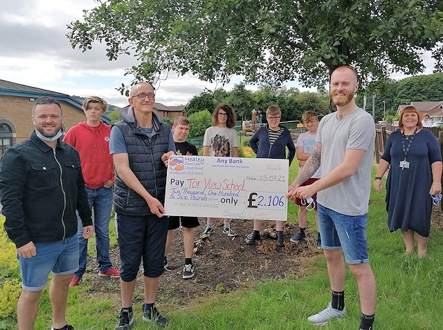 Healey Care Ltd hand the Friends of Tor View School a cheque