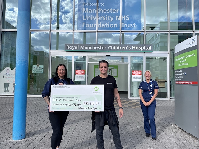 Toni and Lance outside Royal Manchester Children's Hospital with one of their fundraising cheques