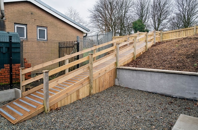 Non-slip decking strips on a new ramp give access to a grassed activity area at the back of the building