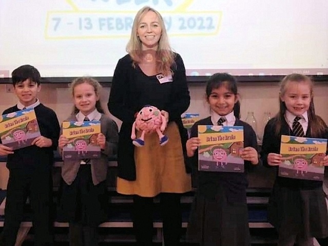 Dr Louise Mansell with schoolchildren and copies of her Brian the Brain book