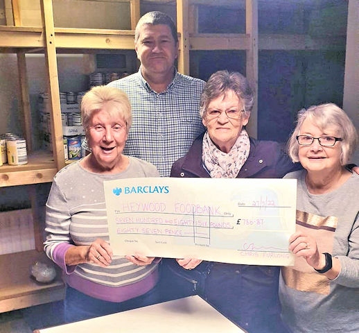 Chris Furlong gives a cheque to Heywood Foodbank