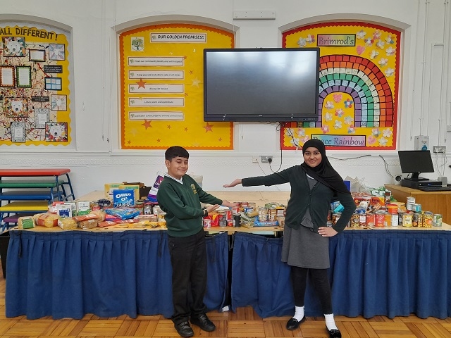 Brimrod Primary’s Head Boy Umar and Head Girl Alina with the Harvest collection for Rochdale Foodbank