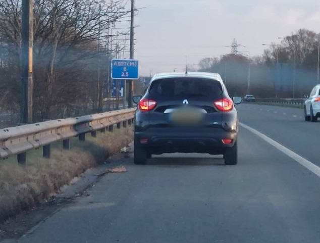 The black Renault was stopped as the driver was putting on make-up