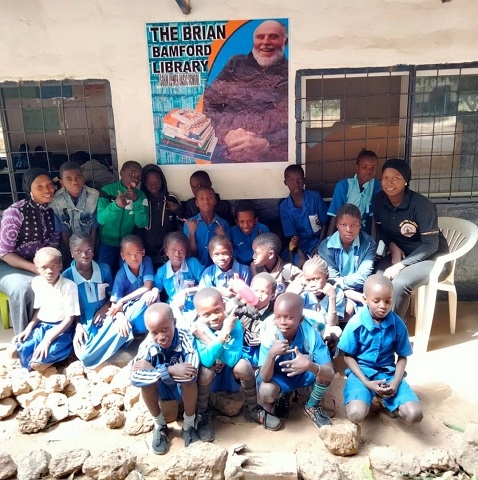 Some of the children and teachers with the mural they created, after a small ceremony of remembrance and dedication