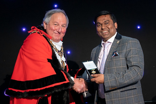 Former mayor councillor Ali Ahmed is presented with a past mayors medallion by new mayor Mike Holly