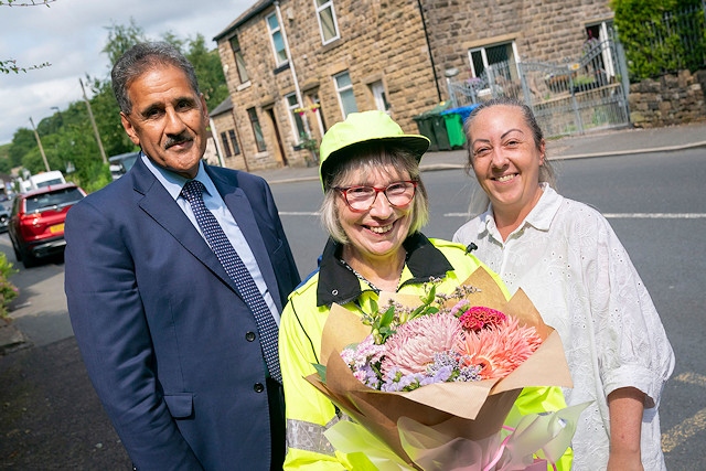 Jacqueline Robinson (centre) is thanked by Councillor Shah Wazir who made a surprise visit to congratulate her after her shift alongside Nicola Mcilvenny, school crossing patrol supervisor at Rochdale Borough Council