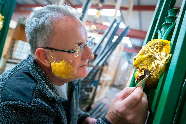 David Thelwell from J3 UK Engineering brushes the gold leaf against his face to build up static to enable it to more easily attach to his brush