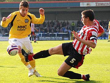 Brentford's John Mackie puts in a tackle of Rochdale striker Adam Le Fondre