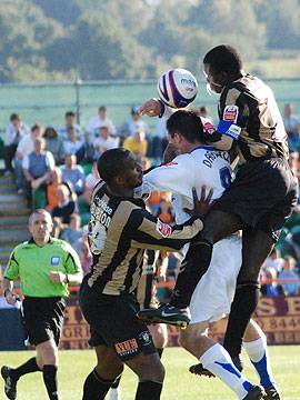 Dagnall is sandwiched between two defenders