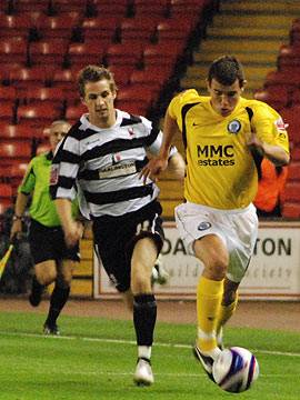 Adam Rundle carries the ball away from his marker