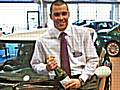 Carcraft sales executive posing with a car and a bottle of champagne