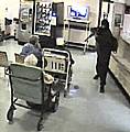 CCTV still shows Charlton pointing the gun at an elderly woman in a wheelchair.