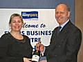 Kirsty Gorrill receiving a bottle of champagne from Managing Director, Tom Stokes.