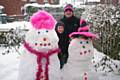 Emma Lord and 7-year-old Tyler Hughes of Castleton with the snowmen they have built