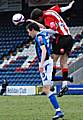 Mark Phillips wins a header against Will Buckley.