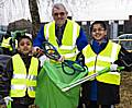 Head teacher Jed Morgan and two pupils get rid of a cable dumped carelessly outside school.