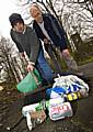 Members of the Spotland Tenants and Residents Association, Marcus Whipp and Brian True, help to shovel up some rubbish.