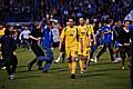 Dismayed Dale players leave the pitch as Gillingham fans begin their celebrations.