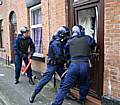 Officers break down a door during the drug raids.