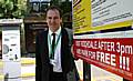 Councillor Greg Couzens next to one of the signs indicating free parking after 3pm.