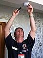 Phil Greenwood from the Fire and Rescue Service fits a smoke alarm 