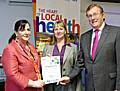 Shahnaz Ali presents Rachel Snow-Miller with barriers award, alongside NHS HMR chairman John Pierce.