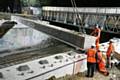 A large crane lowers the first new bridge beam into place across the railway, in the middle of the night