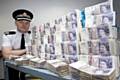 Assistant Chief Constable Terry Sweeney from Greater Manchester Police with money from the Proceeds of Crime Act 