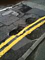 Yellow lines painted over a pothole on Chadwick Hall Road