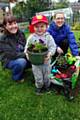 Meggie Heap, Community Project Manager, Seddon, Ayden Heap, 3, Mhorag Saxon, Project Officer, Groundwork Oldham & Rochdale, planting donated violas with new tools 
