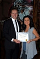 Caroline Abrahams receiving a certificate of achievement from Greg Couzens 
