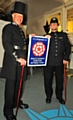 Volunteers Tom Hughes and Ron Flowers showing off the Quality Assured Visitor Attraction (QAVA) status sign. 

