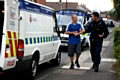 A suspect being led away by a police officer 