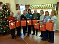 Kenneth Davies, MBE, and Bernard Percy from the Rochdale Freemasons presenting the gifts to some of the Day Care staff at Springhill Hospice