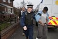 A man being led away by police during the raids 