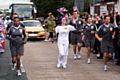 Luci Teal running down Bolton Road with the Olympic Torch in front of hundreds of flag-waving locals 
